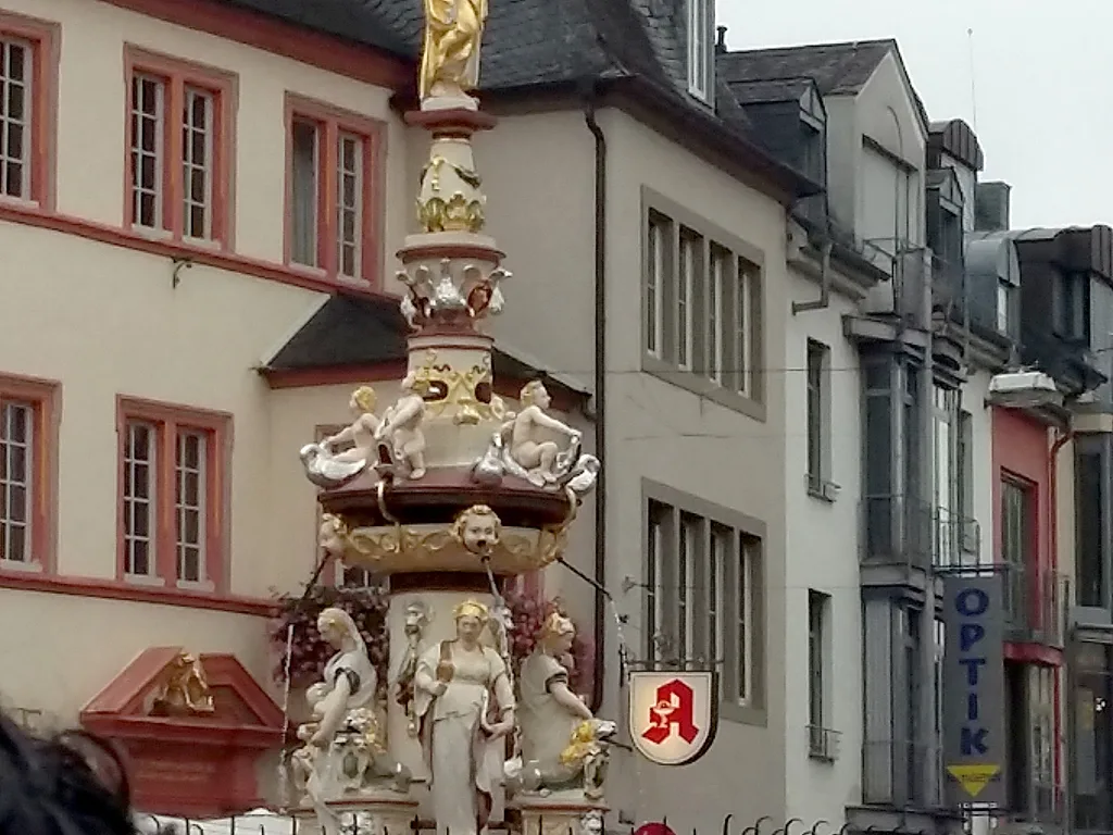 Verzierter Brunnen zwischen den Häusern der Altstadt.